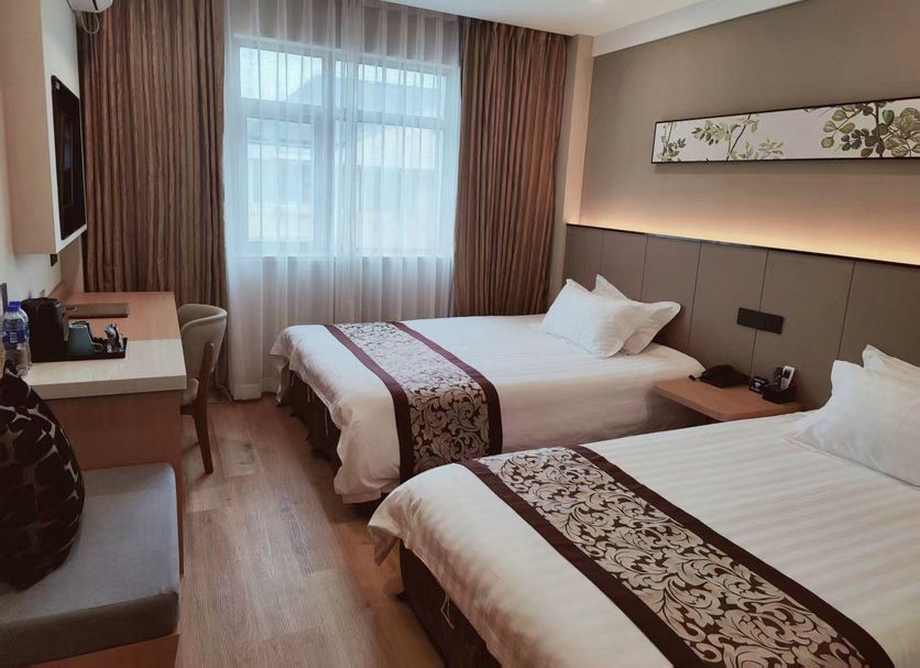Yangjianhua Hotel (Shanghai Hu'nan) guest room with two beds, desk, and large window in Shanghai