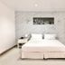 Lopburi Inn Hotel room in Lop Buri with a double bed and marble-pattern accent wall
