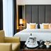 Melia Paris Champs Elysees guest room in Paris with a king bed, bedside lamps, and seating area