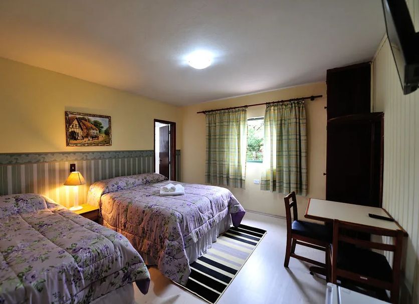 Pousada Villa Romana in Campos do Jordão, twin bedroom with striped curtains and desk