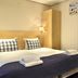 Fletcher Badhotel Egmond aan Zee room with twin bed, navy throw, wardrobe and wall mirror