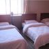 Jia Hao in Beijing room with three single beds beside a bright window