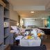 Castelmar Hotel in Florianopolis room with dining table, bedroom area, and wall-mounted TV