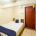 Casavilla Travellers Lodge Pudu in Kuala Lumpur: compact single room with bed, TV, and wooden door