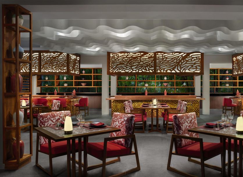 Anantara Veli Maldives Resort restaurant with patterned chairs, tables, and decorative shelving in Veligandu Huraa