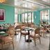 the goodtime hotel Miami Beach dining room with teal walls, wicker chairs and large windows