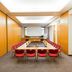 Dormero Hotel Dresden City meeting room in Dresden with conference table, red chairs and projector screen