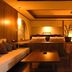 Miyako Gero Hot Spring room with sofa, coffee table, armchairs and king bed in warm lighting