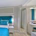 Glamour Hotel Istanbul Sirkeci guest room with turquoise bedspread, upholstered headboard and vanity in Istanbul