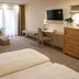 Waldblick Kniebis hotel room in Freudenstadt with twin beds, seating area, desk and TV