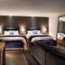 Auberge du Lac-a-l'Eau-Claire room in Saint-Alexis-des-Monts with two beds, sofa, and dining table