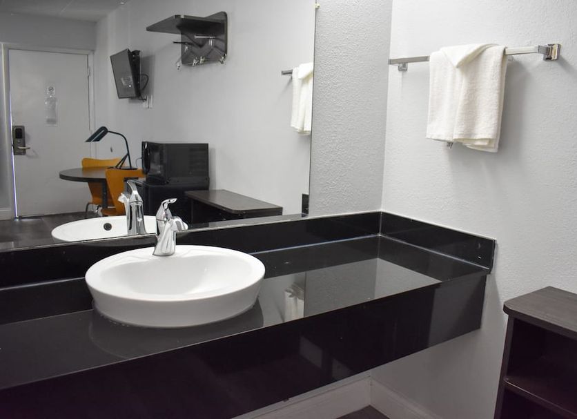 Motel 6 Columbus Oh - Osu North bathroom vanity with round sink, black countertop, mirror and towels