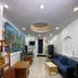 Funny Guesthouse, Ho Chi Minh City: simple lounge with blue sofa, tables, artwork, and recessed ceiling lights