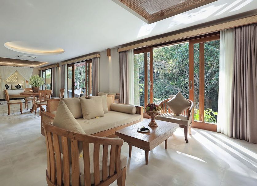 The Sankara Suites and Villas in Ubud, airy suite with floor-to-ceiling forest-view windows and seating area