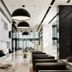 S31 Sukhumvit Hotel in Bangkok lobby with long marble table, black chairs, and pendant lights