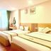 Royal Hotel Hanoi twin bedroom with two beds, window curtains, and warm wood headboard