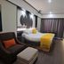 Zhehai Hotel Ningbo room with projector screen, bed, armchair, and gray curtains in Ningbo.