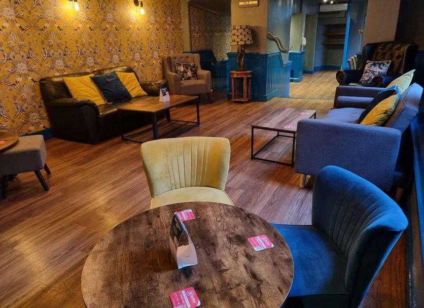 OYO The Leven Felixstowe lobby lounge with sofas, chairs, tables and patterned wallpaper