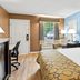 Baymont by Wyndham Forest City guest room with king bed, desk, chair, and window view