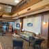 Quality Inn Perrysburg lobby with chandelier, staircase, seating area and wood-paneled walls