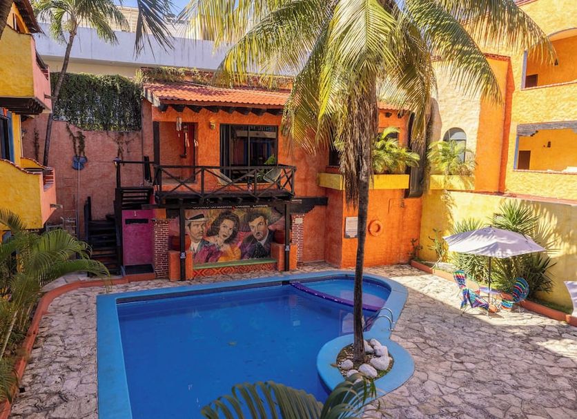 Hotel Hacienda Maria Bonita in Playa del Carmen with palm-framed courtyard pool and lounge chairs