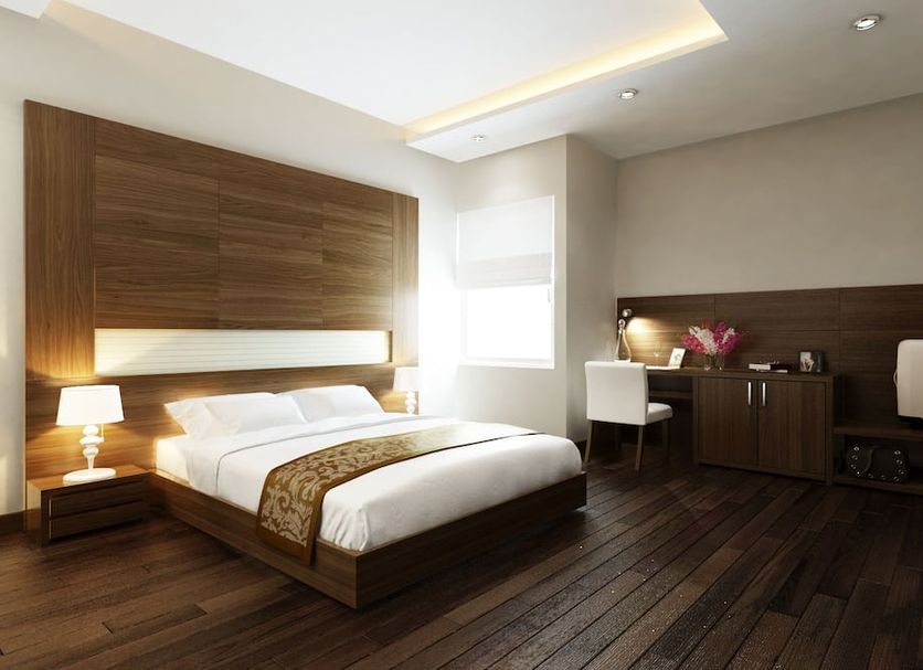 Eco Luxury Hotel Hanoi guest room with king bed, desk, and warm wood flooring in Hanoi