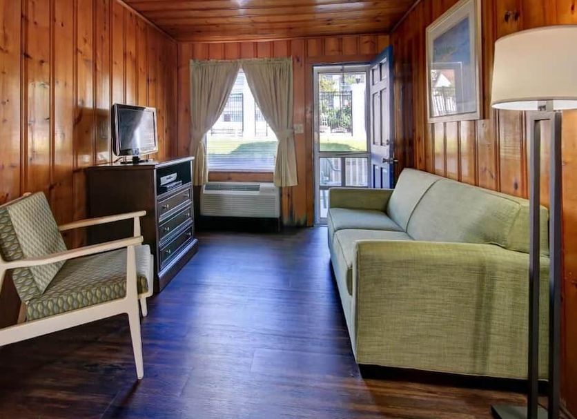 Castle in the Sand in Ocean City: cozy wood-paneled guest room with sofa, chair, and oceanfront window view
