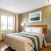 HomeTowne Studios by Red Roof Denver - Lakewood West room with bed, window, and lamp