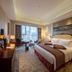 Grand Metropark Guofeng Hotel Tangshan guest room with king bed, desk, and floor-to-ceiling window view