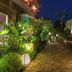 Sahaja Sawah Resort in Tabanan night garden walkway with tropical plants and statues