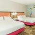 Hampton Inn Garden City guest room with two double beds and colorful wall accents