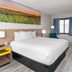 Days Inn by Wyndham Mason City guest room with king bed, window, desk chair and TV