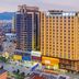 Marriott Hotel in Yunfu, high-rise city hotel at dusk with street-level shops and mountain backdrop