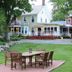 Saratoga Farmstead B&B in Saratoga Springs with lawn, patio seating, and a white farmhouse exterior