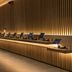 Zedwell Piccadilly Circus in London, softly lit lounge with rows of lounge chairs along a wood slatted wall