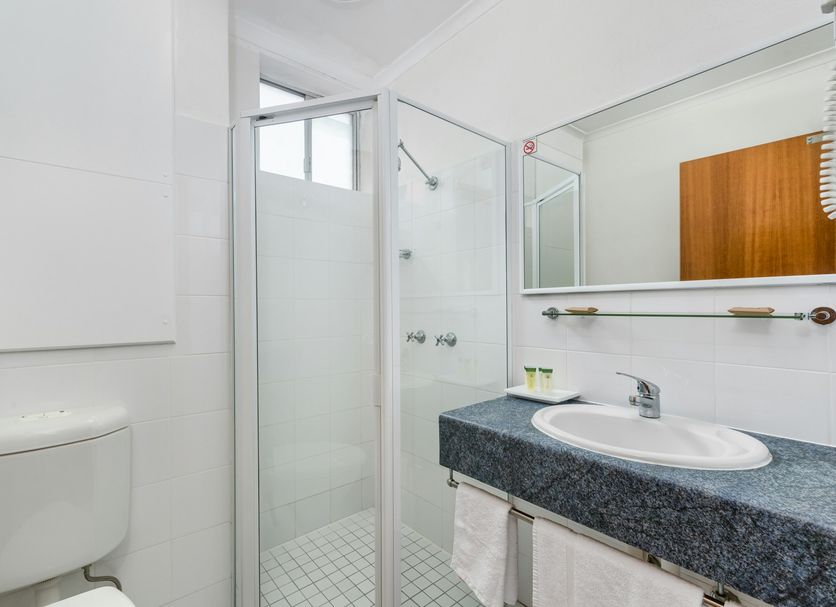 Tudor Inn Newcastle bathroom with shower, sink, mirror and toilet in Newcastle