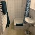 Bathroom at Zum armen Mann in Düsseldorf with shower, small tub, sink, and towel radiator