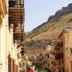 Case D'anna in Castellammare del Golfo with balcony-lined street and mountain backdrop