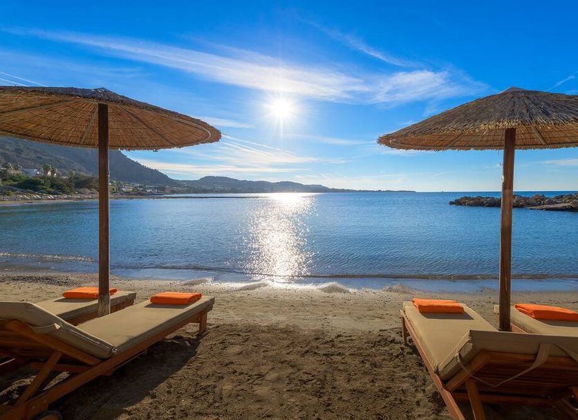 Sunrise Hotel in Pefki beach with sun loungers, straw umbrellas and calm sea view