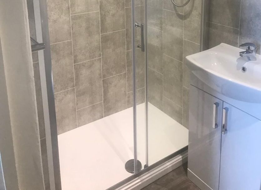 Atlantis, Torquay bathroom with glass-enclosed shower and wall-mounted sink