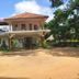 Thirumalai Park in Nilaveli: two-story hotel building with red roof, surrounded by trees and open grounds