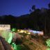 Hotel Costa Rossa in Porto with illuminated hillside terrace and pool at dusk