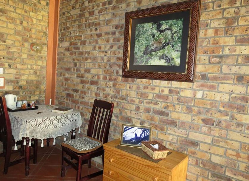 Serenity Du Bois Lodge in Marloth Park, rustic room with small table, chairs and brick wall art
