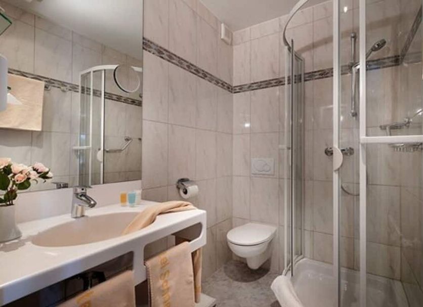 Hotel Sonneneck in Bad Kissingen bathroom with sink, toilet, mirror and glass shower enclosure