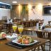 San Diego Suites Governador Valadares restaurant table with plated salads and orange drinks