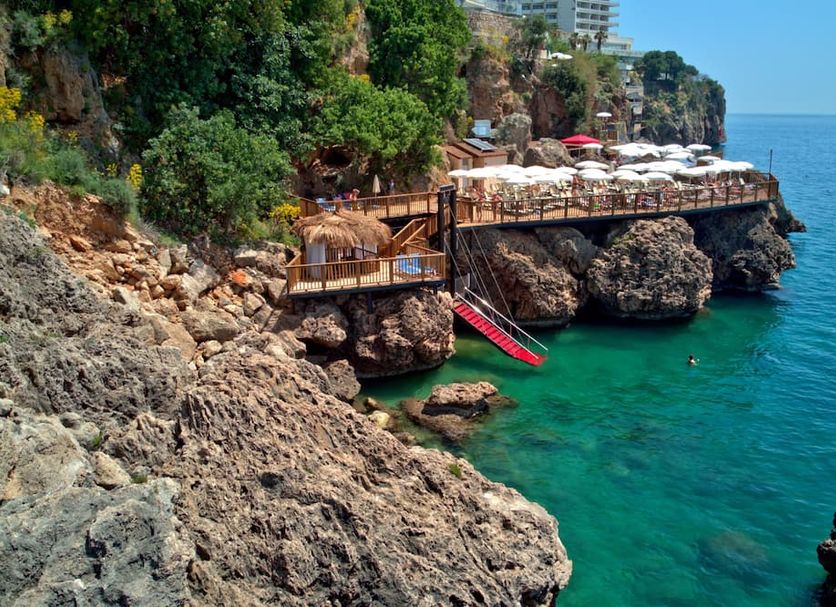 Ramada Plaza by Wyndham Antalya with cliffside terrace, sun loungers and clear blue sea in Antalya