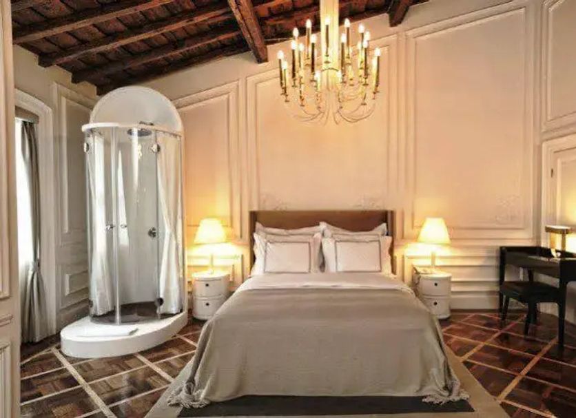 The Stay Galata in Istanbul features an elegant bedroom with chandelier, canopy shower, and desk