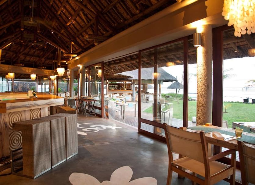 Tamassa Resort in Bel Ombre with open-air bar, thatched roof, and oceanfront lawn views