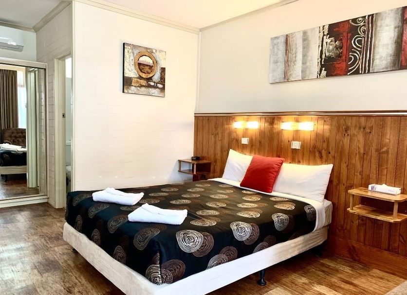 Central Motel Mildura room with double bed, wood-paneled headboard and mirrored wardrobe in Mildura