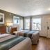 HomeTowne Studios by Red Roof Austin guest room with two beds, window view and wood flooring